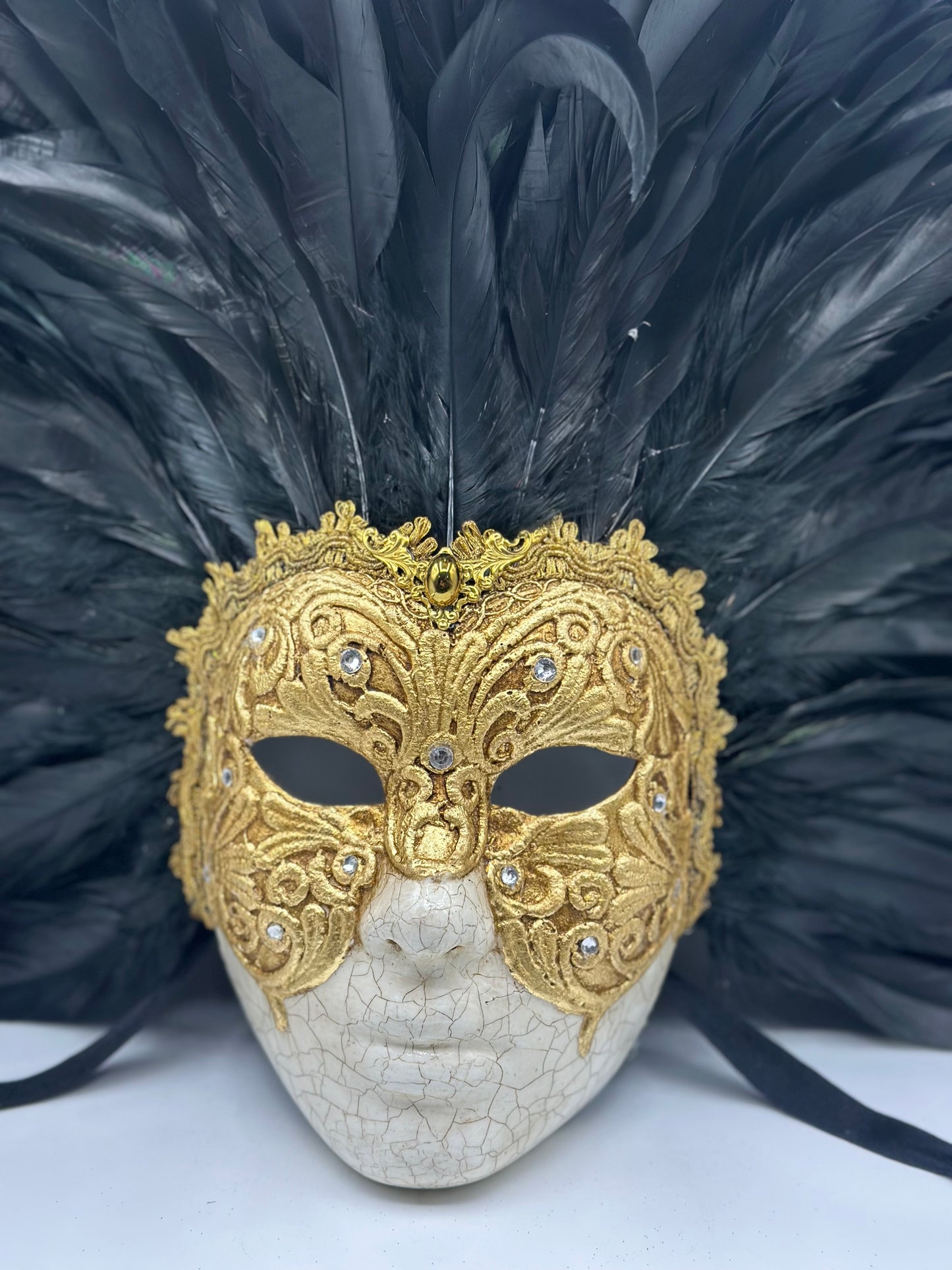 Máscara de rostro completo con plumas negras y dorado