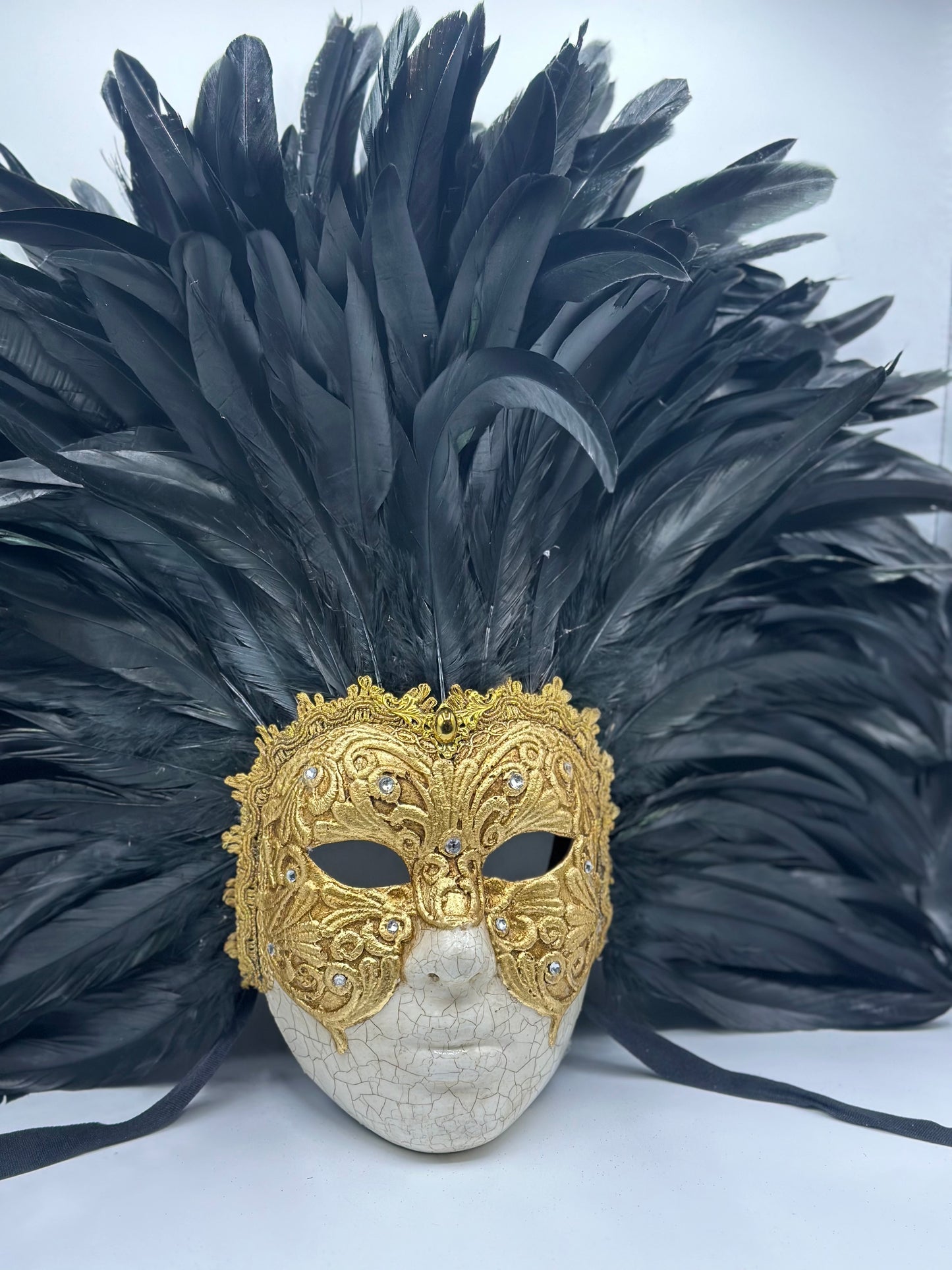 Máscara de rostro completo con plumas negras y dorado