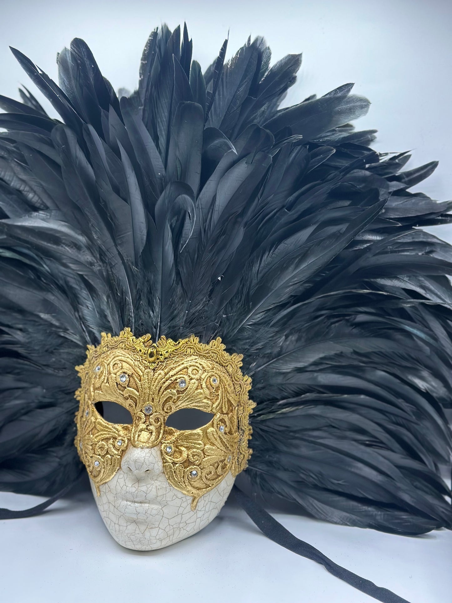 Máscara de rostro completo con plumas negras y dorado