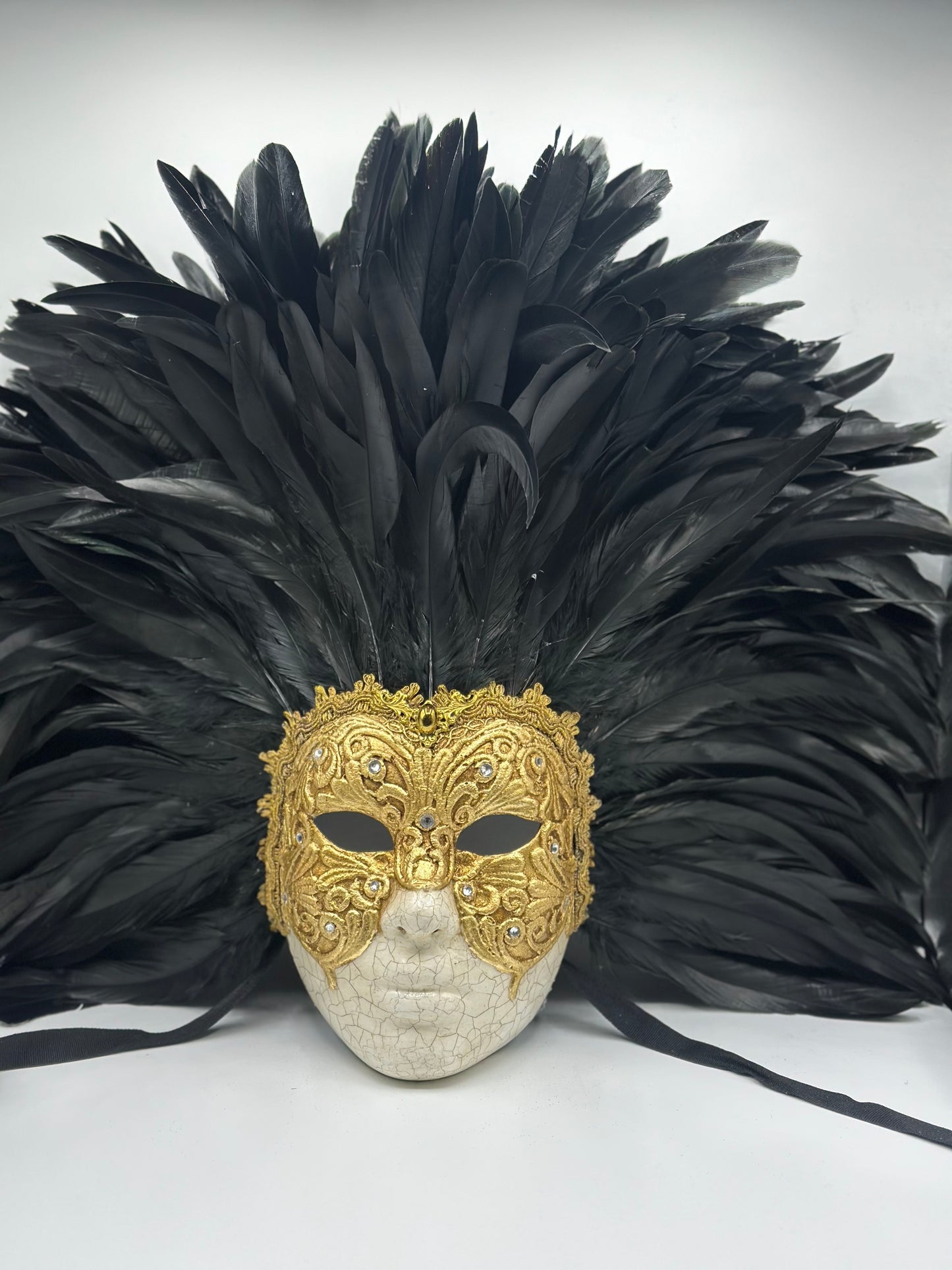 Máscara de rostro completo con plumas negras y dorado